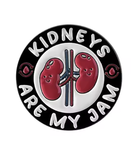 “Round hard enamel pin featuring two smiling kidneys with veins and arteries, surrounded by the words ‘Kidneys Are My Jam’ in bold white letters.”