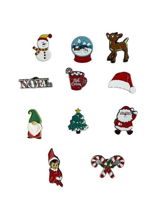 11 Christmas enamel pins of a snowman, snow globe, Rain deer, Noel, hot chololate, Santa hat, Gnome, Christmas tree, Snowman, Elf on the Shelf, and Candy Cane