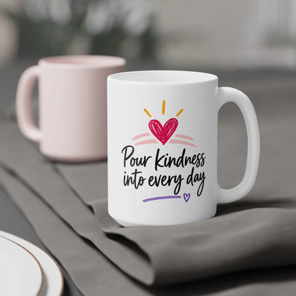 White 15oz ceramic mug with Pour Kindness Into Every Day lettering, raspberry heart and golden rays, styled product view.