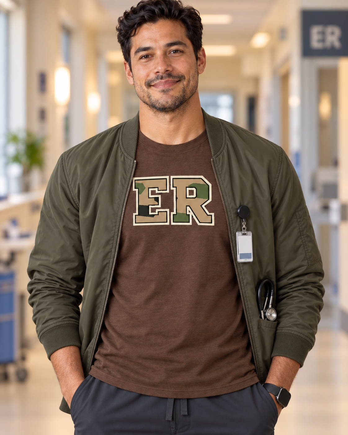 Male nurse wearing a brown Nursify ER Camo short sleeve shirt under an open olive bomber jacket, with a role badge reel.