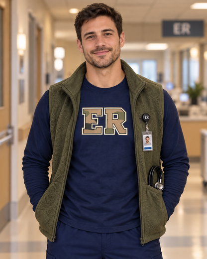 Male nurse wearing a navy Nursify ER Camo long sleeve shirt under an open olive vest, with centred camouflage and cream ER lettering.