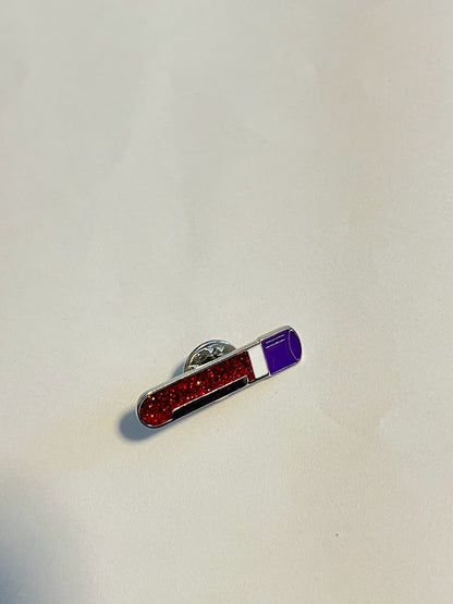 Vial of blood enamel pin in purple and white with red glitter detail | 0.7 cm x 3.1 cm