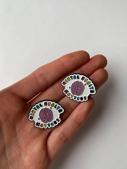 Mental Health Matters enamel pin held in a hand to show its 2.8 cm size