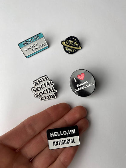 Introvert enamel pins with quotes, size shown compared to an average-sized woman’s hand