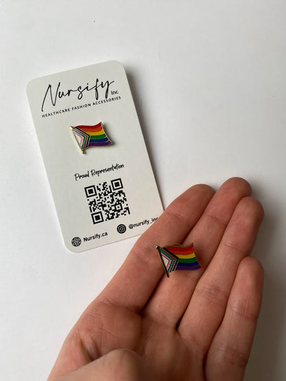 Progress pride flag enamel pin with wavy multicolor design | size shown compared to an average-sized woman’s hand