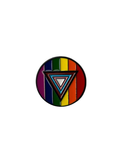 A round enamel pin with vertical rainbow pride stripes as the background and a layered triangle symbol in the center, outlined in black, representing inclusive pride and 2SLGBTQIA plus support.