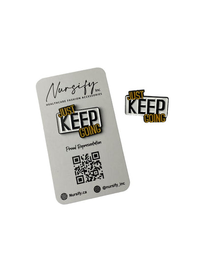 Just keep going enamel pin in white, black, and yellow text design 