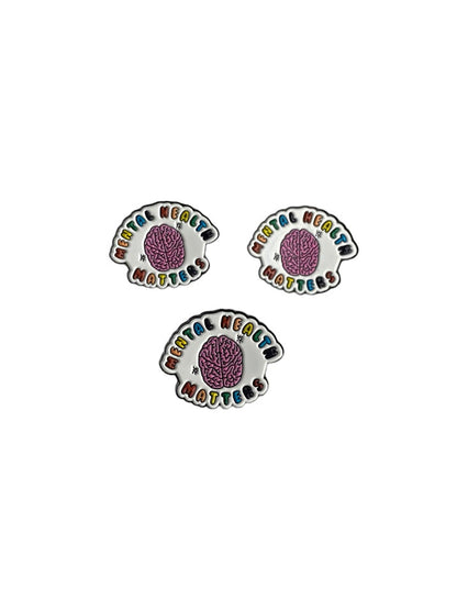 Mental Health Matters enamel pin with pink brain and rainbow lettering on a white background