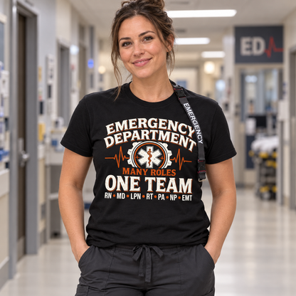 Nurse wearing black Many Roles One Team emergency department shirt with RN MD LPN RT PA NP EMT lettering and Emergency lanyard