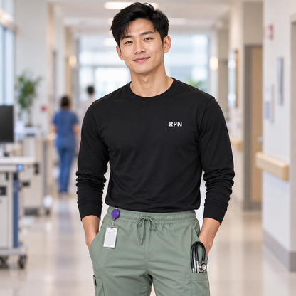 Male nurse wearing a black Nursify RPN long sleeve shirt tucked into sage scrub pants.