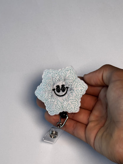 9. Smiling Snowflake. Actual Smiling Snowflake Badge Reel held in hand; hand shown for visual reference only