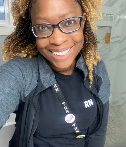 Nurse modelling a black RN T-shirt with matching RN lanyard and work jacket